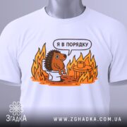 Футболка з їжаком в порядку. Біла футболка на манекені, з принтом їжака на унітазі. Принт яскравий, з оранжевими вогнями. Фон світлий, з легким градієнтом.