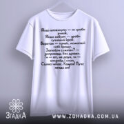 Футболка з кумедними написами, білого кольору, підвішена на вішалці, фон світло-сірий, принт чорного кольору з текстом на українській мові.