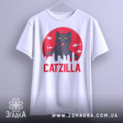 Футболка з принтом Catzilla білого кольору, зображена з фронтального ракурсу, фон світло-сірий, принт містить чорного кота на червоному фоні з силуетами міста та вертольотами.