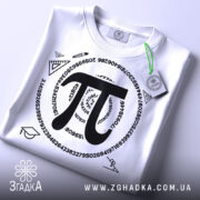 Футболка з символом пі, білого кольору, складена на столі, фон світлий, принт чорного кольору з числом пі та математичними символами, на футболці зелений ярлик.