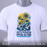 Футболка життя крізь бетон крупним планом, видно деталі дизайну з соняхами.