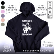 Худі я директор подарунок. Чорний колір, зображення спереду, фон білий. Принт з малюнком директора в кріслі з мегафоном, текстом "ТОМУ ЩО Я ДИРЕКТОР". Кишеня-«кенгуру» внизу, капюшон на верху, манжети та пояс з еластичної тканини.