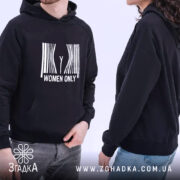 Худі тільки жінки подарунок. Чорний колір, зображено з бокового ракурсу, фон світлий. Принт на грудях білий, з написом 'WOMEN ONLY'. Видно двох людей, один з яких носить худі, капюшон та манжети з еластичної тканини.