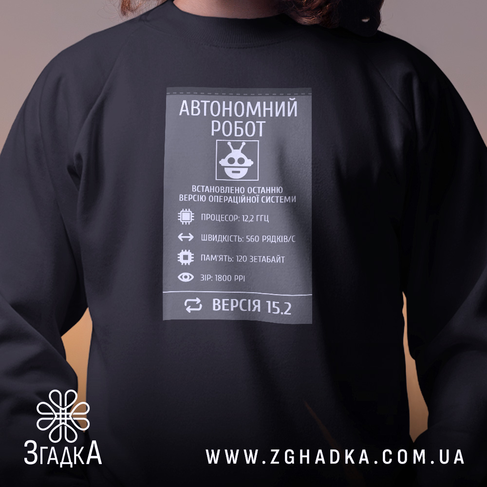 Світшот автономний робот подарунок чорного кольору, зображений на людині з довгим волоссям, ракурс спереду, фон з нейтральним освітленням, принт з інформацією про автономного робота, кругла горловина, манжети з трикотажної резинки, трикотажна резинка на поясі, фактура м'яка та комфортна.