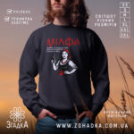 Світшот мілфа зцілює чоловіків. Чорний колір, зображений на чоловікові з бородою, ракурс з переду, фон з м'якими відтінками заходу сонця. Принт з жінкою в червоному, кругла горловина, манжети на рукавах, трикотажна резинка на поясі, фактура м'яка і приємна на дотик.