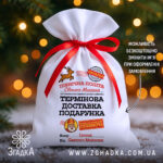 Мішечок пошта Миколая білий габардин із червоною стрічкою та принтом “Термінова доставка подарунка” на фоні ялинки.