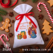 Мішечок до Дня Миколая серед пряників і ялинкового декору, чіткий принт із подарунками та Святим Миколаєм.