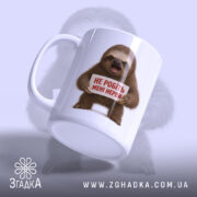 Чашка для дуже нервових, біла з блискучою поверхнею, зображення ведмедя-лінивця, що тримає табличку з написом 'НЕ РОБІТЬ МЕНІ НЕРВи', на фоні світло-фіолетового кольору, ручка класичної форми, край гладкий.