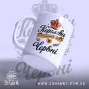 Чашка для прекрасної королеви. Чашка білого кольору з чорним і золотим принтом, з ракурсу зліва. Фон світло-фіолетовий з елементами корони. Ручка класичної форми, край гладкий, поверхня глянцева.