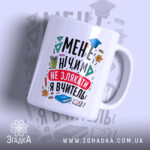 Чашка для вчительки подарунок, біла з яскравим принтом, зображена під кутом, на фоні легкого градієнту, принт містить текст і малюнки, ручка класична, край рівний, глянцева поверхня.