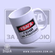 Чашка геній за роботою. Чашка білого кольору з принтом 'УВАГА ГЕНІЙ ЗА РОБОТОЮ', зображена з боку, ручка гладка, край рівний, поверхня має легкий глянець. Фон світло-фіолетовий, з розмитим логотипом.