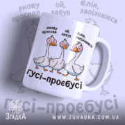Чашка гуси роздовбаї, біла з кольоровим принтом, показує трьох гусей з комічними виразами обличчя, на фоні світло-фіолетового кольору, ручка класична, край рівний, глянцева поверхня.