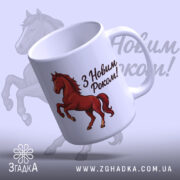 Чашка кінь святковий, біла з малюнком червоного коня, з написом 'З Новим Роком!', ручка з правого боку, край рівний, матова поверхня, фон світло-синій з тінню коня.