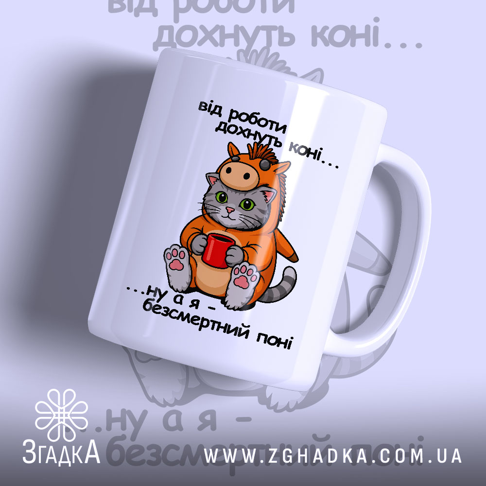 Chashka Koni Poni Idealnyi Podarunok Dlia Liubyteliv 1 Чашка коні поні. Чашка білого кольору з малюнком кота в костюмі поні, що тримає червону чашку. Ручка чашки з правого боку, край рівний, поверхня глянцева. На фоні розмитий малюнок з написом.