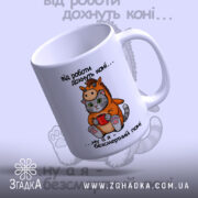 Чашка коні поні. Чашка білого кольору з малюнком кота в костюмі поні, що тримає червону чашку. Ручка чашки з правого боку, край рівний, поверхня глянцева. На фоні розмитий малюнок з написом.