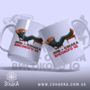 Чашка лінь високий IQ, біла, зображення з двох боків, фон світло-фіолетовий, принт з чоловіком, що лежить на стільці, текст чорний і червоний, ручки гладкі, край рівний, глянцевий.