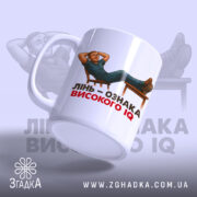 Чашка лінь високий IQ, біла, зображення з правого боку, фон світло-фіолетовий, принт з чоловіком, що лежить на стільці, текст чорний і червоний, ручка гладка, край рівний, глянцевий.