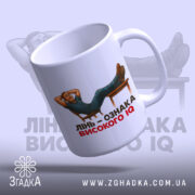 Чашка лінь високий IQ, біла, зображення з лівого боку, фон світло-фіолетовий, принт з чоловіком, що лежить на стільці, текст чорний і червоний, ручка гладка, край рівний, глянцевий.