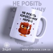 Чашка мем для офісу, біла, зображена з правого боку, на фоні світло-фіолетового кольору, принт з малюнком сови та текстом "НЕ РОБІТЬ ЮРІЙОВИЧУ НЕРВИ!", ручка класична, край рівний, глянцева поверхня.