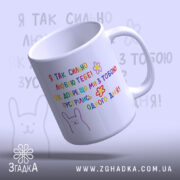 Чашка на річницю зустрічі, біла, з кольоровим принтом, на якому написано: 'Я ТАК СИЛЬНО ЛЮБЛЮ ТЕБЕ!' та малюнок зайця. Ручка кругла, край гладкий, глянець на поверхні чашки, фон світло-фіолетовий.