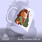 Чашка новорічний коник подарунок, біла, зображення коника з зеленим светром, тримає ялинку, ручка кругла, край рівний, глянцева поверхня, фон світло-синій.