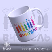 Чашка початкова школа вчитель, біла з кольоровими олівцями на принті, напис 'ВЧИТЕЛЬ' внизу, ручка кругла, край рівний, глянцева поверхня, фон світло-сірий.