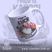 Чашка пустотливий єнот. Чашка білого кольору з малюнком єнота, що лежить на фоні вогню, з верхнього ракурсу. Ручка кругла, край рівний, поверхня глянцева. Напис: 'Грішити та кайфувати! Бешкетуй та насолоджуйся!'