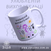 Чашка улюбленій виховательці, біла з кольоровим принтом, малюнки дітей, сонця та автомобіля, ручка з правого боку, край рівний, глянцева поверхня.