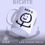 Чашка з мемом Бісите, біла, з легким глянцем, зображення на передній частині, де напис 'БІСИТЕ' чорного кольору, усміхнений персонаж, що показує два пальці, ручка класична, край рівний.