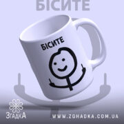 Чашка з мемом Бісите, біла, з легким глянцем, зображення на передній частині, де напис 'БІСИТЕ' чорного кольору, усміхнений персонаж, що показує два пальці, ручка класична, край рівний.