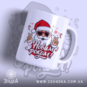 Чашка з Новим роком, біла, з ракурсу спереду, фон світло-фіолетовий, принт з веселим дідом Морозом у червоній шапці та окулярах, напис 'З Новим роком!' червоним кольором, ручка стандартна, край рівний, глянцева поверхня.