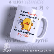 Чашка жорсткий жарт офісу: біла чашка з жовтим каченям, що тримає сокиру, на фоні світло-фіолетового кольору, текст на українській мові, ручка кругла, край гладкий, матова поверхня.