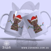 Чашка злий новорічний кіт, біла, два ракурси кота в червоній шапці та гірлянді, ручки з обох боків, глянець на поверхні, фон світло-сірий.