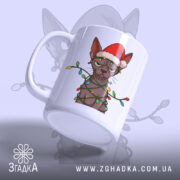 Чашка злий новорічний кіт, біла, зображення кота в червоній шапці та гірлянді, ручка з правого боку, глянець на поверхні, фон світло-сірий.