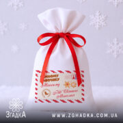 Дитячий подарунковий мішечок — білий із червоною стрічкою та принтом “Пошта Святого Миколая”.