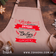 Фартух бабуся дякуємо крупним планом на дерев’яному столі з новорічним декором.