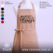 Фартух бабуся готує на манекені бежевого кольору з чорним кулінарним принтом.