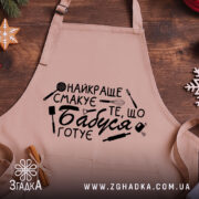 Фартух бабуся готує, розкладений на столі, крупний план принта з кухонними іконками.