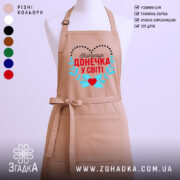 Фартух для донечки із принтом «Найкраща донечка у світі» на манекені, бежевий колір.