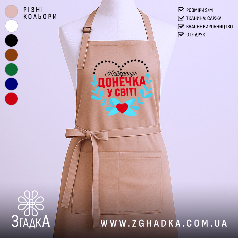 fartukh-dlia-donechky-yaskravyi-podarunok-iz-sertsem-1 Фартух для донечки із принтом «Найкраща донечка у світі» на манекені, бежевий колір.