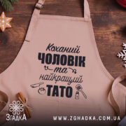 Фартух коханий чоловік крупним планом на дерев’яному фоні із святковим декором.