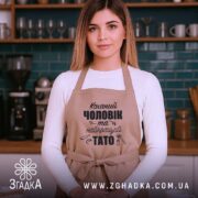 Фартух коханий чоловік на молодій жінці в кухні, чітко видно принт та крій.