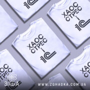 Футболка 1с хаос стрес, кілька складених футболок на світлому фоні, ракурс зверху, принт чорний з текстом 'ХАОС СТРЕС i 1С'.