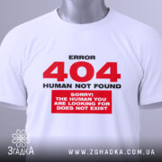 Футболка 404 human not found, біла, складена на поверхні, фон світло-сірий, принт червоний з текстом 'ERROR 404 HUMAN NOT FOUND' та 'SORRY! THE HUMAN YOU ARE LOOKING FOR DOES NOT EXIST', на комірці зелена етикетка.