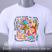 Футболка абстрактні емоції, біла, зображена зверху на столі, фон світло-сірий, принт кольоровий, з елементами абстрактних облич, на футболці є етикетка з зеленим шнурком.