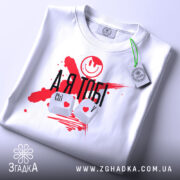 Футболка айті романтика, біла, складена на поверхні, фон світло-сірий, принт з червоними плямами, смайлом та написом 'А Я ТОБІ', клавіші Ctrl і V з сердечками, на етикетці зелена стрічка.