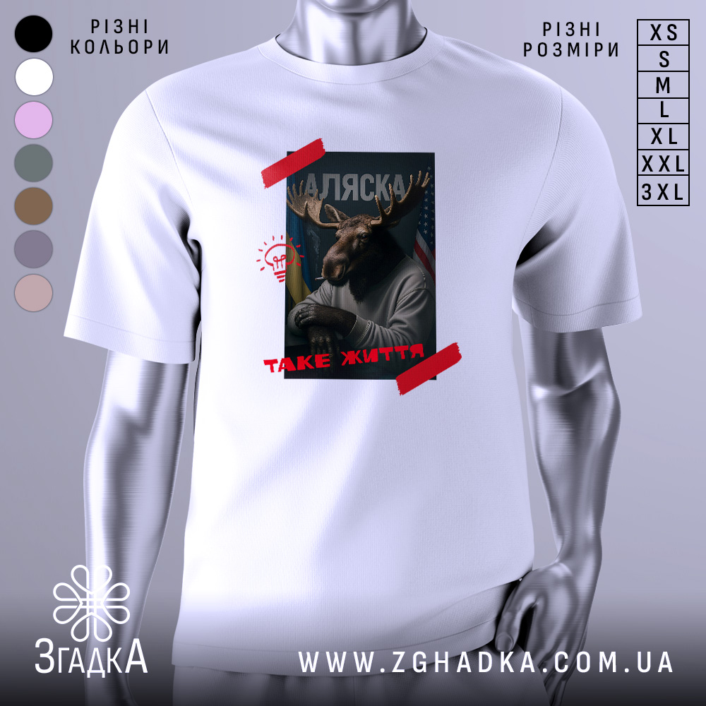 Futbolka Aliaska Take Zhyttia Styl Ta Komfort 1 Футболка Аляска таке життя, біла футболка з принтом, зображення оленя з рогами, на фоні прапорів України та США, текст 'ТАKE ЖИТТЯ' червоним кольором, ракурс спереду.