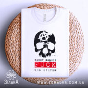 Футболка анархія проти системи, біла, зображена на плетеній основі, фон світлий, принт з черепом та анархічним символом, текст 'TRUST NOBODY FUCK THE SYSTEM' червоного кольору.