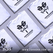 Футболка анонімний український, біла, зображена на манекені з правого ракурсу, фон світлий, принт чорного кольору з зображенням маски та написом 'АНОНІМНИЙ, але український!'.