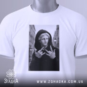 Футболка античний стріт, біла, складена на столі, фон світло-сірий, принт з чорно-білим зображенням статуї в капюшоні, яка показує жест, з етикеткою на шнурку.